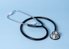 Close-up of a classic stethoscope on a blue background, symbolizing healthcare and medical profession.