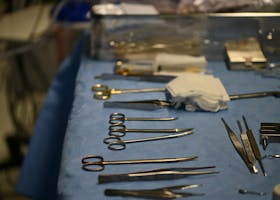 A close-up of various surgical tools neatly arranged on a sterile blue table in a hospital setting.