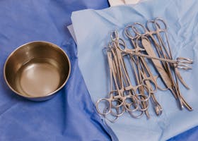 Sterile surgical instruments laid out on blue surgical drapes ready for medical procedures in a clinical setting.