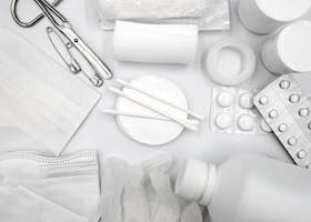 A flat lay of essential first aid supplies including bandages, gloves, and medications.