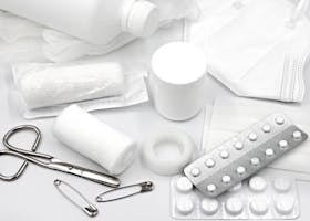 A flat lay of essential first aid supplies and medical equipment on a white background.