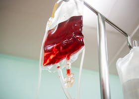 Blood bag connected to an IV line in a clinical setting, emphasizing healthcare and emergency treatment.