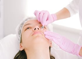 Woman receiving a facial cosmetic injection in a professional clinic setting.