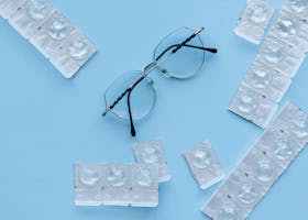 Eyeglasses and contact lenses on a blue background. Concept of eye care and vision correction.