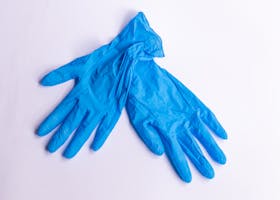 A pair of disposable blue latex gloves on a clean, white surface representing hygiene and safety.