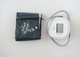 A digital sphygmomanometer on a white background, used for measuring blood pressure.